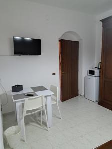 a white table and chairs in a room with a kitchen at La Foggia seaside paradise in Siculiana