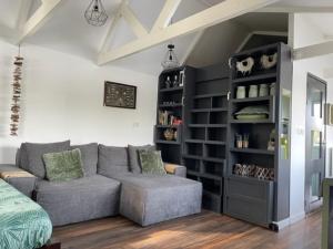 a living room with a couch and a book shelf at Aangenaam op de Rijn, woonboot, inclusief privé sauna in Alphen aan den Rijn