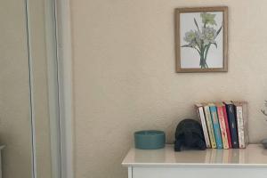 a shelf with books and a picture on a wall at Immaculate 3-Bed House in Durham near Sedgefield in Trimdon Grange