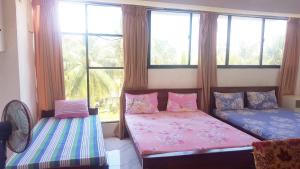 1 dormitorio con 2 camas y ventana en Beehive Colombo en Colombo