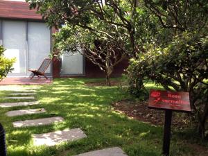 a sign in the yard of a house with a lawn at Quinta das Rosas Villas in Ribeira Grande