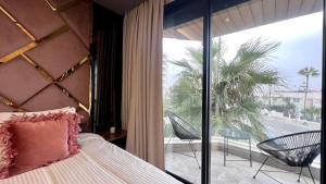 een slaapkamer met een bed en een balkon met een palmboom bij The Address - Sunny Anfa Hills in Casablanca