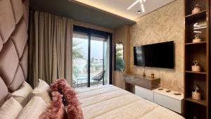 een slaapkamer met een groot bed en een televisie bij The Address - Sunny Anfa Hills in Casablanca