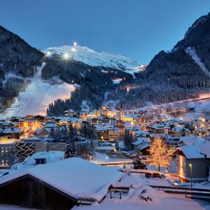 une ville couverte de neige dans les montagnes la nuit dans l'établissement Place2be, à Ischgl