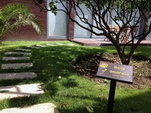a sign in the grass in front of a house at Quinta das Rosas Villas in Ribeira Grande