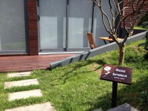 a sign in the grass in front of a house at Quinta das Rosas Villas in Ribeira Grande
