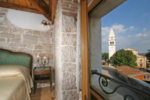 a bedroom with a view of a church tower at Kastel Kastelir in Kaštelir