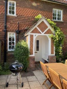 - un barbecue en face d'une maison dans l'établissement Cottage 2, Northbrook Park, Farnham-up to 6 adults, à Farnham