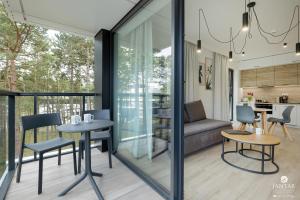 a room with a balcony with a table and chairs at Shellter Apartments 117 Ł - by Jantar Apartamenty in Rogowo