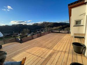 a wooden deck with a view of the mountains at Appartement Eifelglück in Pelm