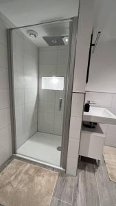 y baño con ducha y lavamanos. en Appartement Eifelglück, en Pelm