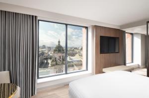a bedroom with a large window with a view of the city at AC Hotel by Marriott Glasgow in Glasgow