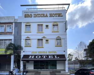 振林山Srg Indira Hotel的一座白色的建筑,上面标有酒店标志