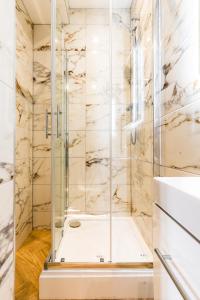 a glass shower in a bathroom with marble walls at Dreamy Derby City Apartment Free Wi-Fi & Parking in Derby
