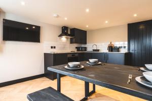 a kitchen with a wooden table with bowls on it at Dreamy Derby City Apartment Free Wi-Fi & Parking in Derby