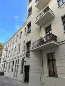 ein weißes Gebäude mit Balkon auf der Seite in der Unterkunft P-122 Piotrkowska Apartment. in Łódź