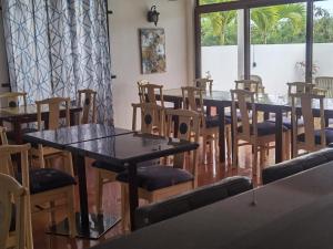 un grupo de mesas y sillas en una habitación en Grand Bay Apartments en Grand Baie
