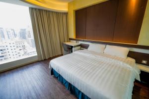 a hotel room with a bed and a large window at Epoch Hotel in Hong Kong