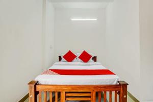 Un dormitorio con una cama con almohadas rojas. en Flagship Thottunkal Building Thodupuzha en Neriyamangalam