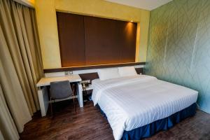 a hotel room with a bed and a desk and a table at Epoch Hotel in Hong Kong