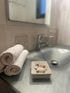 a bathroom sink with towels and a plate with seashells at Golden Eagle House 
