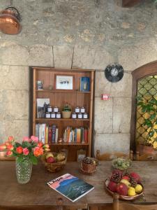 a table with fruit and a book shelf with books at Auberge Lou Jas in Soleilhas