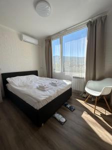 una camera con un letto e una sedia e una finestra di Rose's apartment , self check-in, close to metro a Sofia