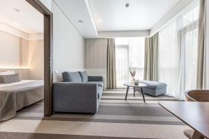 een hotelkamer met een bed, een stoel en een spiegel bij Grand Baltic Dunes in Palanga