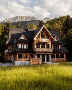 una casa de madera con montañas en el fondo en Stary Niedźwiedź, en Zakopane