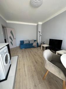un soggiorno con divano blu e lavatrice di Rose's apartment , self check-in, close to metro a Sofia