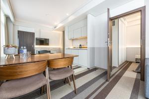 cocina con mesa de madera y sillas en una habitación en Grand Baltic Dunes en Palanga