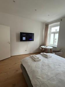 ein Schlafzimmer mit einem Bett und einem TV an der Wand in der Unterkunft Apartment 19 near Metro & Netflix in Wien