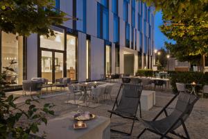 un patio con mesas y sillas frente a un edificio en Stellaris Apartment Hotel, en Garching bei München