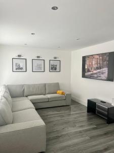 a living room with a couch and a tv at Modern 4 Bed - 10 mins to centre in Liverpool