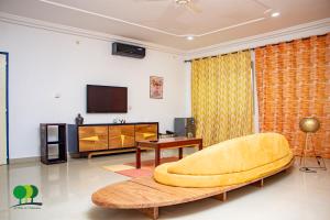 a living room with a yellow couch and a tv at VILLA DE L'INTEGRATION in Ouagadougou