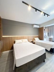 a hotel room with two beds and a kitchen at Apart Hotel em Brasília - MA Empreendimentos in Brasilia