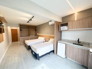 a small room with two beds and a kitchen at Flats em Brasília no Garvey Park Hotel in Brasília