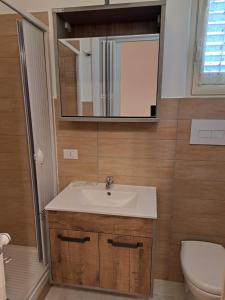 a bathroom with a sink and a toilet and a mirror at La Foggia seaside paradise in Siculiana
