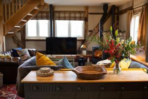 Una sala de estar con un sofá y una mesa de café. en The Byre - Beautiful Contemporary Barn - Hot Tub, en Bridgnorth