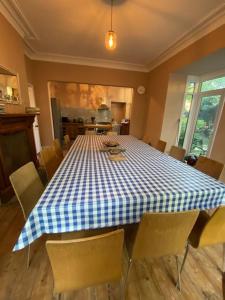 安賽德的住宿－Seaside & Lake District retreat，一间配备有蓝白色格子的桌子和椅子的用餐室