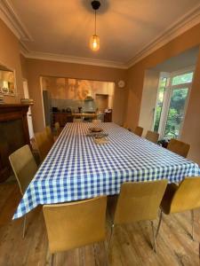 安賽德的住宿－Seaside & Lake District retreat，一间配备有蓝白色桌椅的用餐室