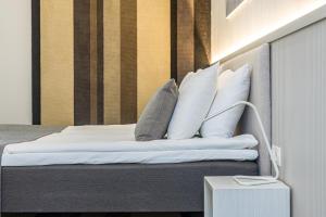 una camera da letto con un letto con cuscini bianchi di Grand Baltic Dunes a Palanga