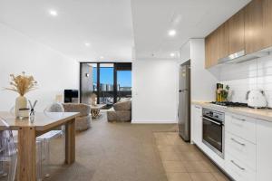 uma cozinha e sala de estar com uma mesa e uma sala de jantar em Adelaide Skyline Serenity: Gym, Pool & views em Adelaide