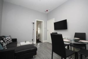 a living room with a table and a dining room at Central Beach Apartment & Free Parking in Blackpool