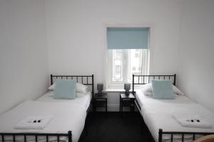 two beds sitting next to each other in a bedroom at Central Beach Apartment & Free Parking in Blackpool