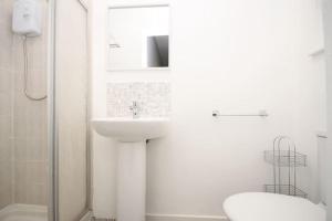 een witte badkamer met een wastafel en een toilet bij Central Beach Apartment & Free Parking in Blackpool