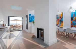 a living room with a fireplace and a table and chairs at Cliffhanger House - Sleeps 12-14 Sea Views in Hollington