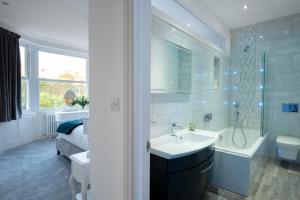 a bathroom with a sink and a tub and a toilet at Big Luxury House sleeps 12/14. Sea Views, Hot tub. in Hollington
