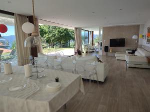 sala de estar con muebles blancos y ventana grande en Casa con vistas al mar en Pontevedra en Pontevedra