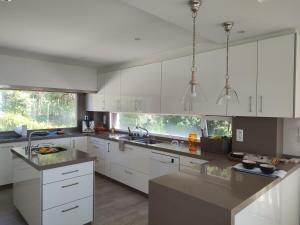 a kitchen with white cabinets and a large window at Casa con vistas al mar en Pontevedra in Pontevedra